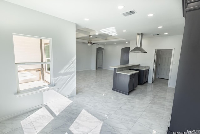 kitchen with arched walkways, recessed lighting, island range hood, visible vents, and a ceiling fan