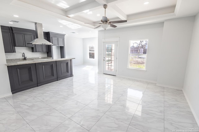 kitchen featuring range hood, ceiling fan, a sink, dark cabinets, and coffered ceiling