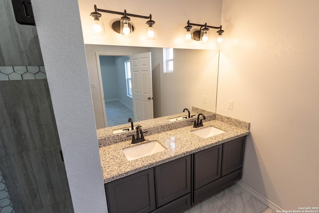 bathroom featuring marble finish floor, a sink, and double vanity