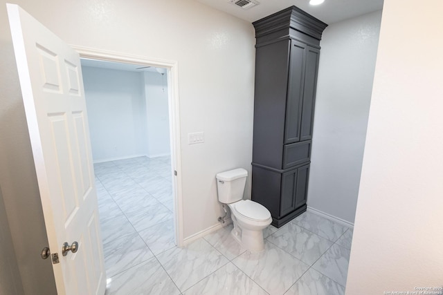 bathroom featuring marble finish floor, visible vents, toilet, and baseboards