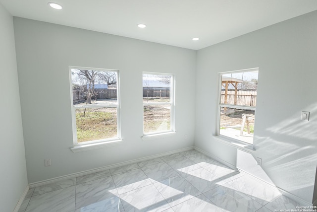 unfurnished room featuring marble finish floor, baseboards, and recessed lighting