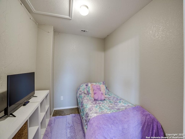 bedroom with dark colored carpet, visible vents, and baseboards