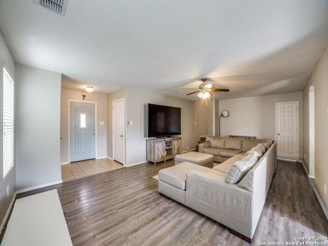 living room with visible vents, ceiling fan, baseboards, and wood finished floors