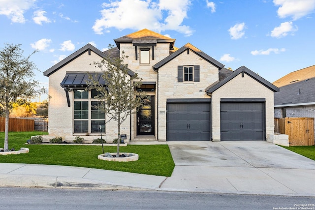 view of front facade with a garage, fence, driveway, stone siding, and a front yard