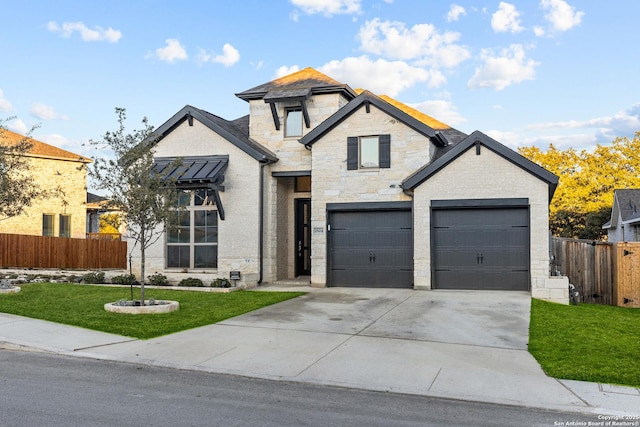 view of front facade featuring a front yard, stone siding, fence, and driveway