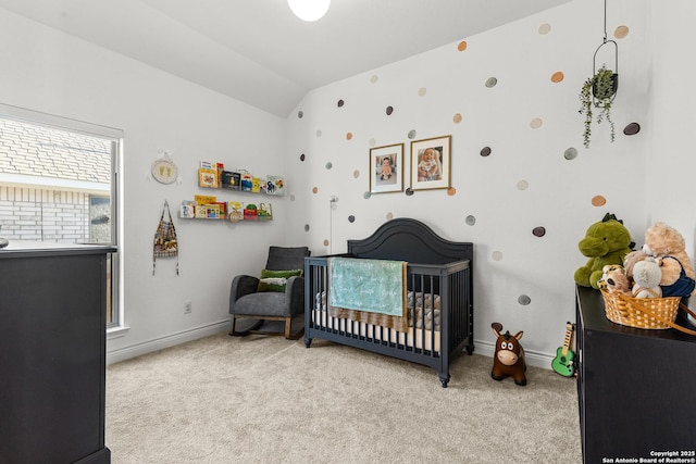 bedroom with light carpet, a nursery area, lofted ceiling, and baseboards