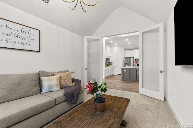 living room featuring lofted ceiling, baseboards, visible vents, and light colored carpet