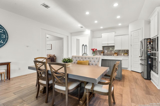 dining room with baseboards, light wood-type flooring, visible vents, and recessed lighting