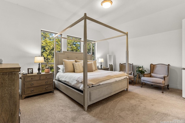 bedroom with vaulted ceiling and light colored carpet