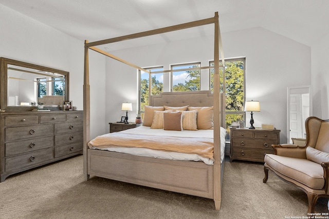 bedroom with vaulted ceiling and light colored carpet