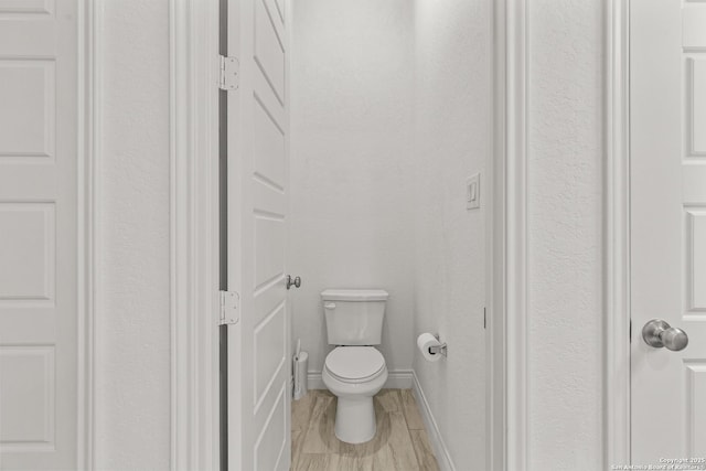 bathroom with toilet and baseboards