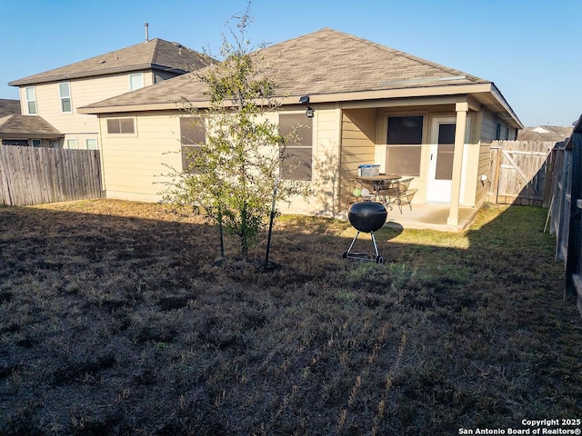 rear view of property with a patio area, a fenced backyard, and a lawn