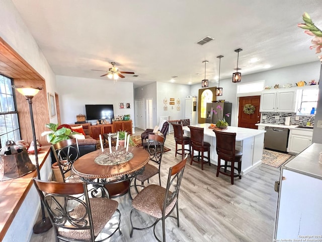 dining area featuring light wood finished floors, visible vents, and a ceiling fan