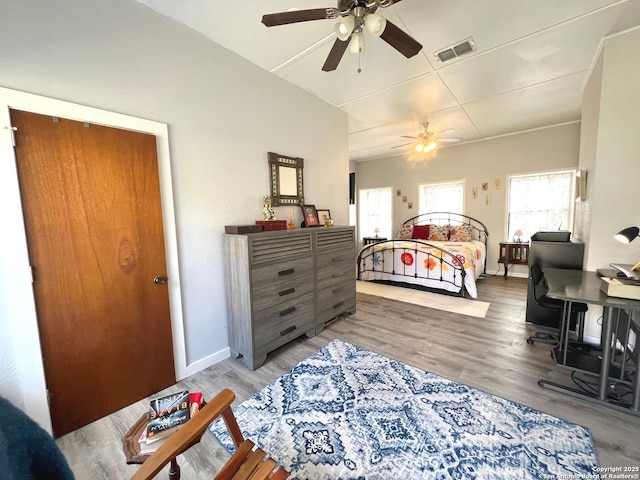 bedroom featuring baseboards, visible vents, and wood finished floors