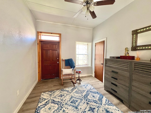 living area featuring baseboards, ceiling fan, and light wood-style floors