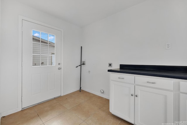 doorway featuring light tile patterned flooring and baseboards