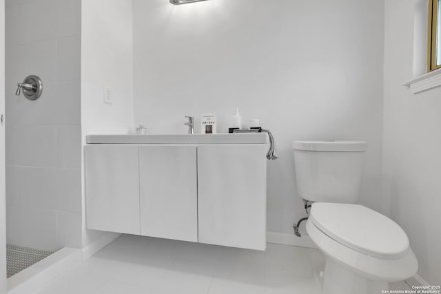 full bath with baseboards, tiled shower, toilet, tile patterned flooring, and vanity