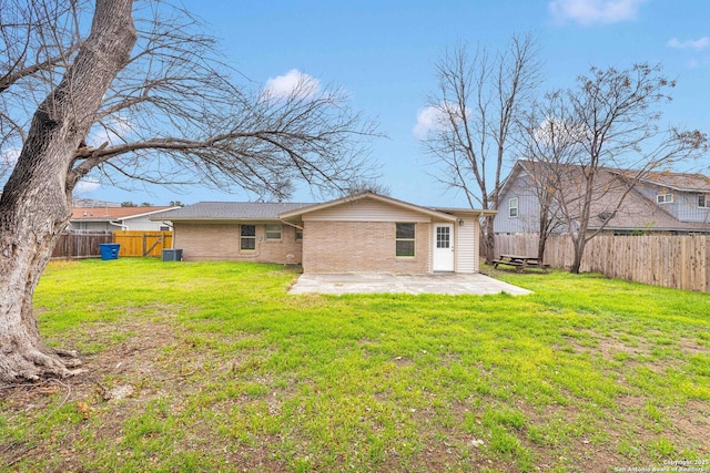 back of house with a patio, cooling unit, a fenced backyard, brick siding, and a yard