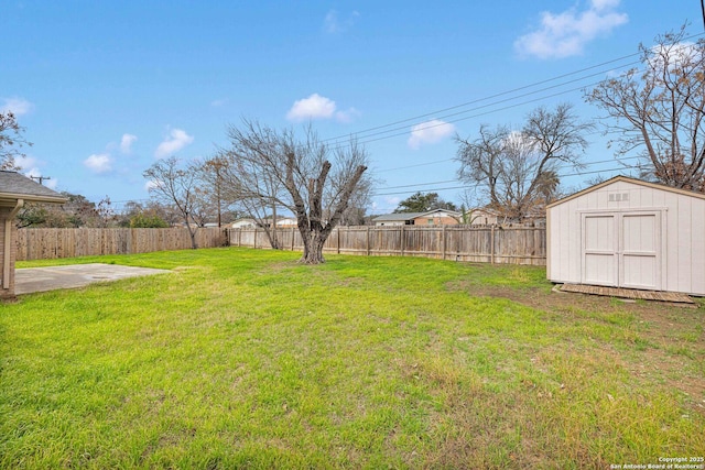 view of yard with a fenced backyard, an outbuilding, and a shed