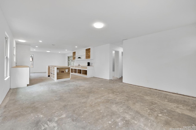 unfurnished living room featuring concrete flooring