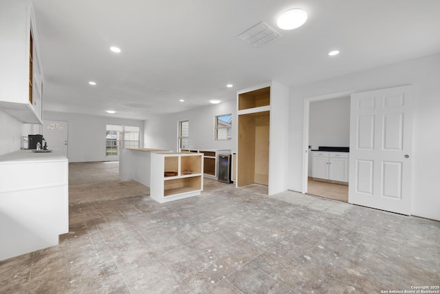 unfurnished room with wine cooler, visible vents, and recessed lighting