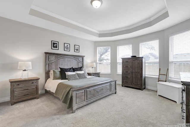 bedroom with baseboards, ornamental molding, a raised ceiling, and light colored carpet