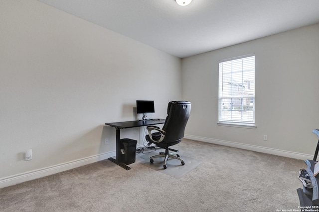 office featuring baseboards and light colored carpet