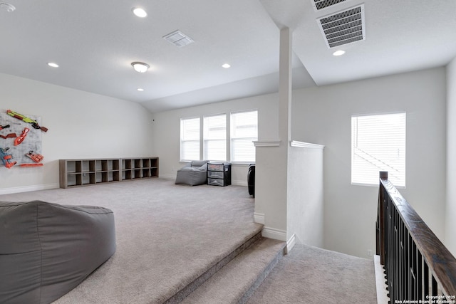 living area featuring visible vents, carpet flooring, vaulted ceiling, an upstairs landing, and baseboards