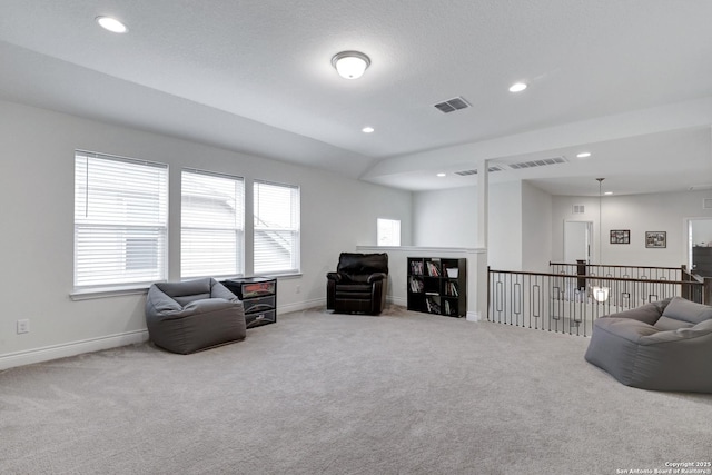 living area featuring carpet floors, visible vents, and baseboards