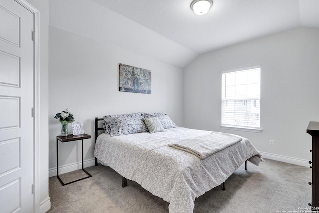 bedroom featuring light colored carpet, vaulted ceiling, and baseboards