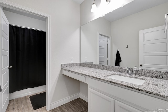 full bathroom featuring wood tiled floor, baseboards, and vanity