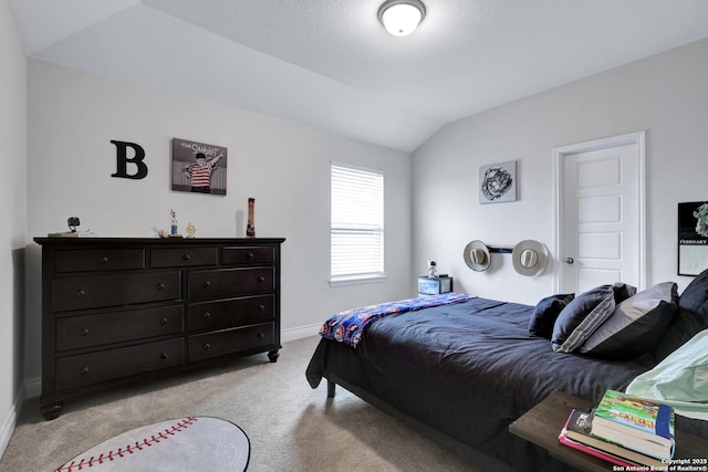 bedroom with vaulted ceiling, light carpet, and baseboards