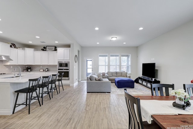 dining space featuring light wood-style floors, baseboards, and recessed lighting