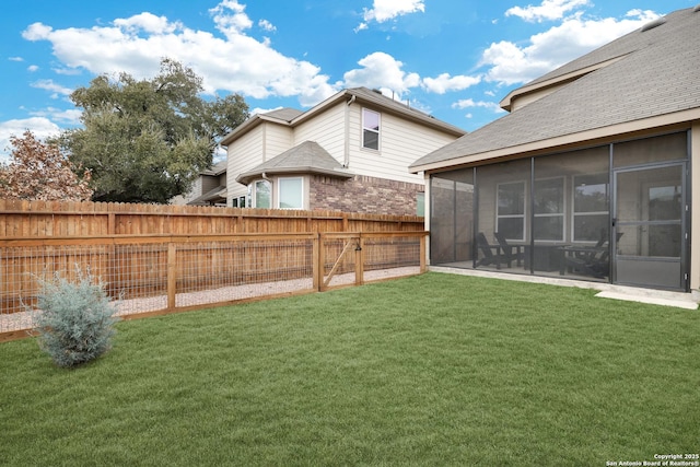 view of yard featuring a sunroom and a fenced backyard