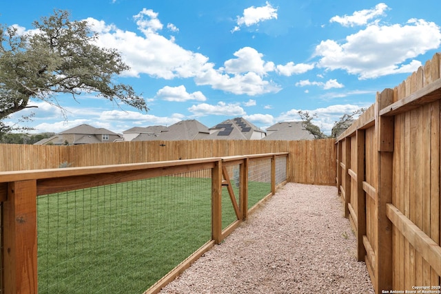 view of yard with a fenced backyard and a residential view