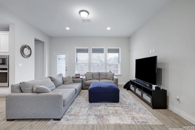 living room with light wood-style floors, baseboards, visible vents, and recessed lighting