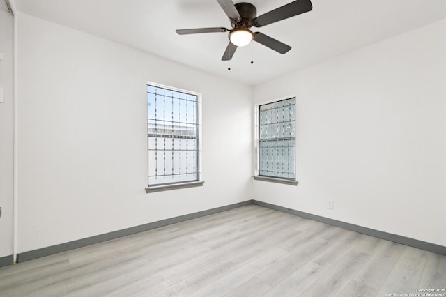 empty room with light wood finished floors, ceiling fan, and baseboards