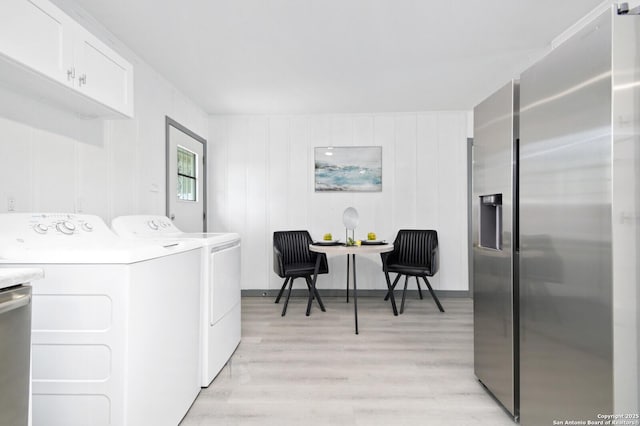 washroom featuring laundry area, separate washer and dryer, and light wood finished floors