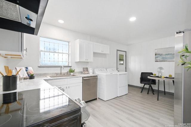 laundry area with laundry area, washer and clothes dryer, light wood-type flooring, a sink, and recessed lighting