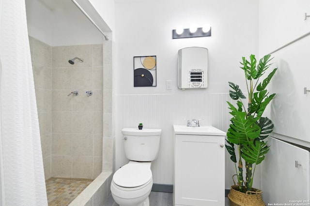 full bath featuring vanity, wainscoting, a shower stall, and toilet