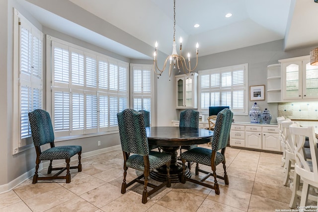 dining room with a wealth of natural light, light tile patterned flooring, baseboards, and an inviting chandelier