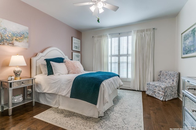 bedroom featuring multiple windows, a ceiling fan, and dark wood-type flooring