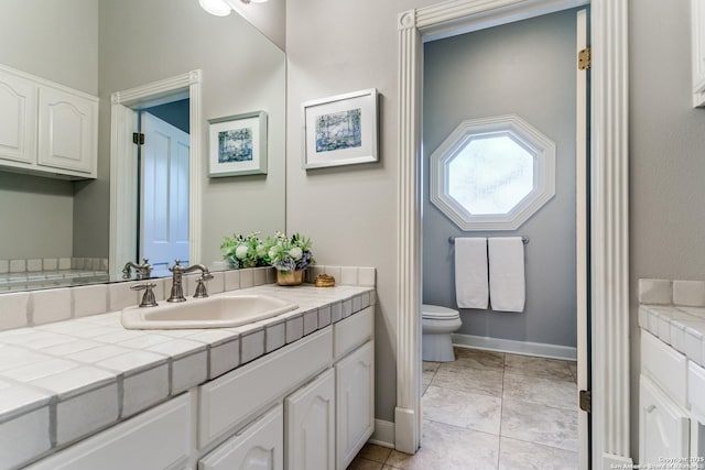 full bathroom featuring baseboards, vanity, toilet, and tile patterned floors