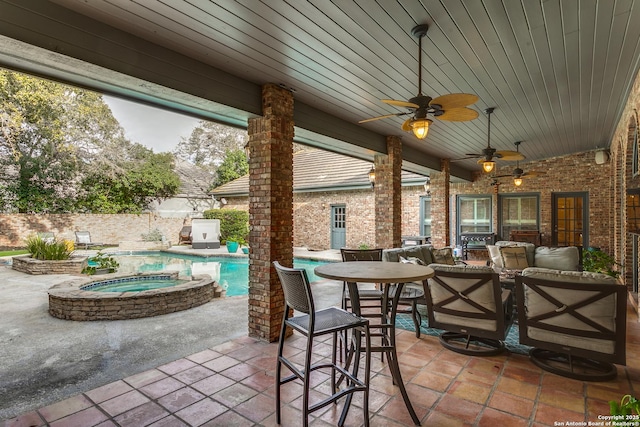 view of patio / terrace with a pool with connected hot tub, fence, and outdoor dining space