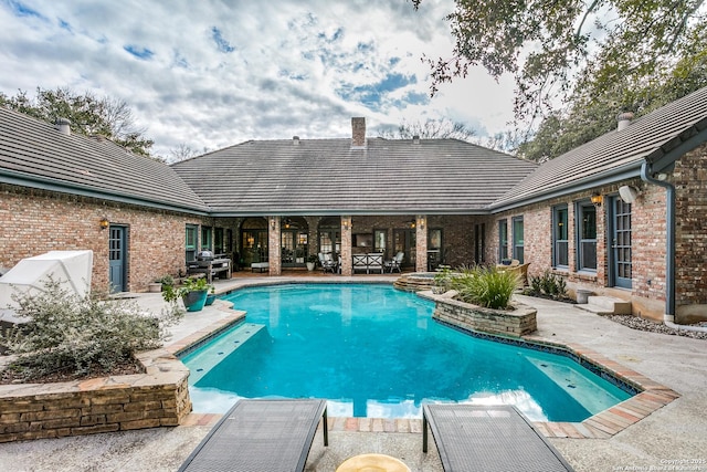 view of pool with a patio and a pool with connected hot tub