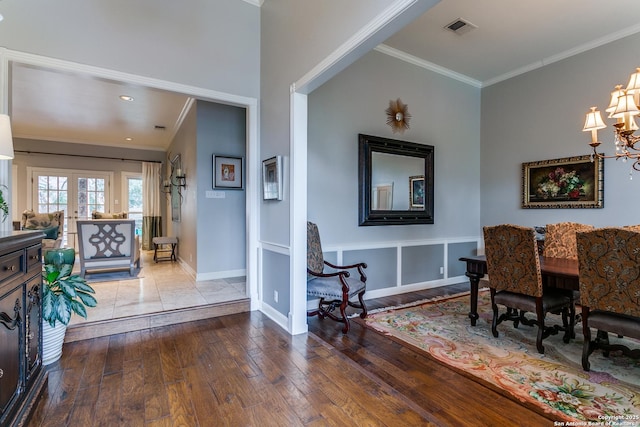 dining area featuring baseboards, visible vents, ornamental molding, wood finished floors, and french doors