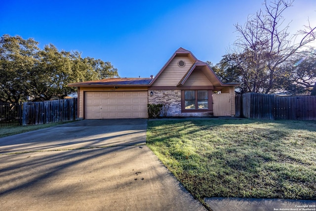 view of front of home with an attached garage, fence, concrete driveway, stone siding, and a front lawn