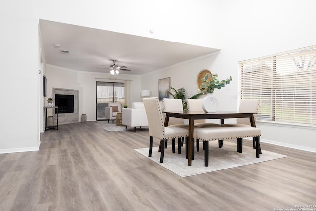 dining space with ceiling fan, visible vents, baseboards, light wood-style floors, and ornamental molding