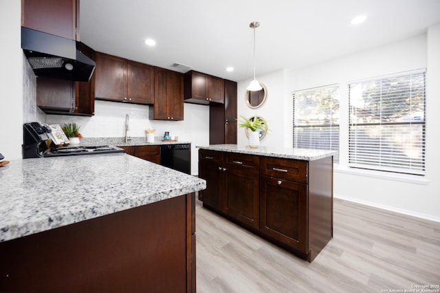 kitchen featuring dark brown cabinetry, under cabinet range hood, pendant lighting, and range