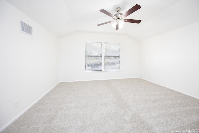 spare room featuring baseboards, visible vents, vaulted ceiling, and a ceiling fan